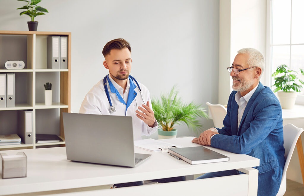 Older man listening to younger doctor.